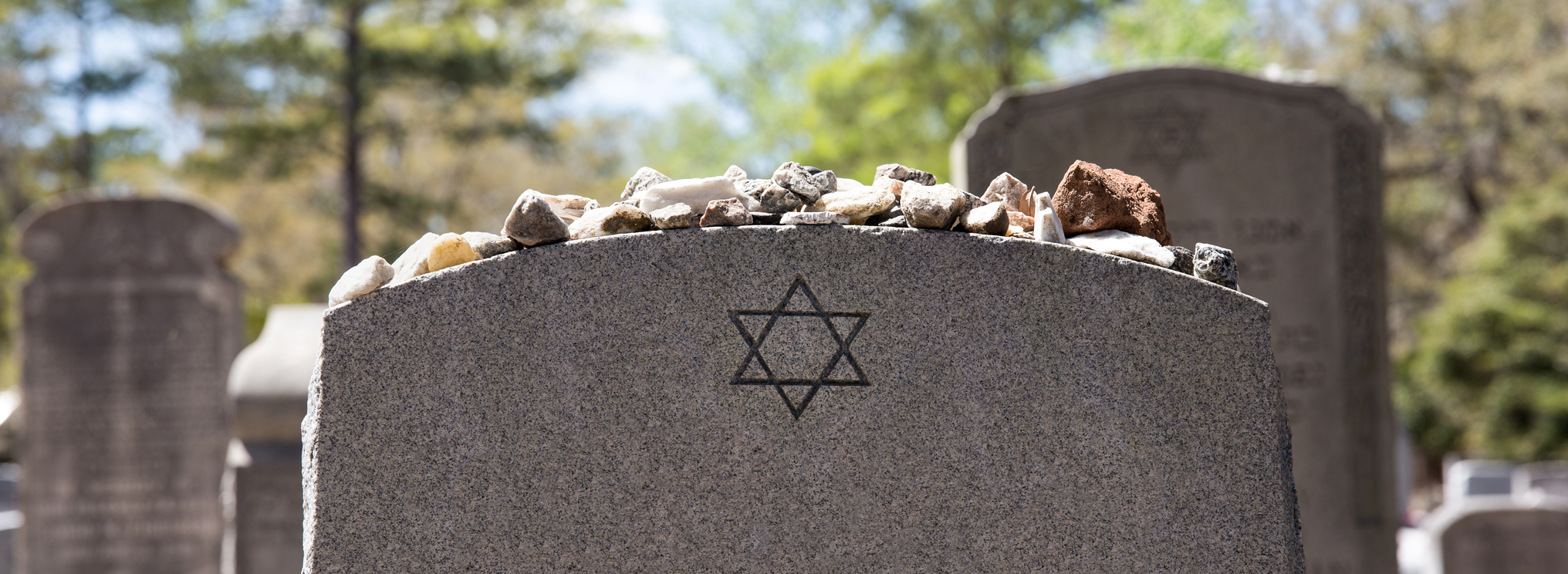 Historischer jüdischer Friedhof mit verwitterten Grabsteinen, hebräischen Inschriften und Davidsternen – Symbol für die jüdische Bestattungskultur und den respektvollen Umgang mit Tod und Erinnerung.